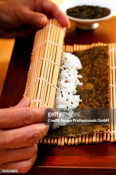 preparing rolled sushi - sushi rice stock pictures, royalty-free photos & images