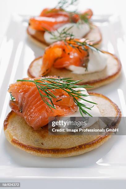 blinis with smoked salmon and sour cream - blini salmon stock pictures, royalty-free photos & images