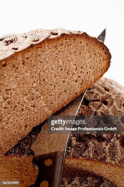 farmhouse bread, cut into pieces, with knife - bread knife stock-fotos und bilder