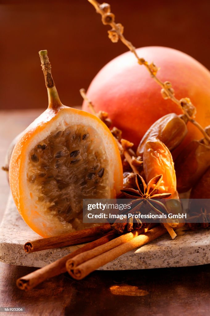 Still life with dates, star anise, cinnamon, granadilla & mango