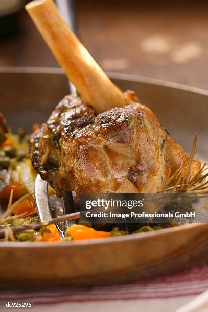 braised lamb shank with vegetables and rosemary in pan - pan stock-fotos und bilder