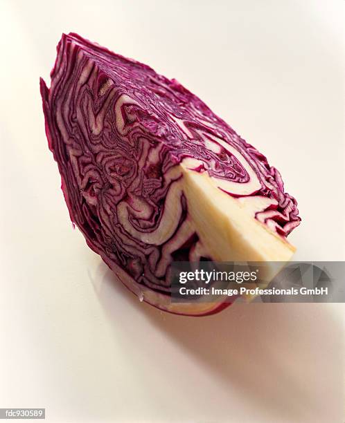 a quarter of a red cabbage on white background - quarter bildbanksfoton och bilder