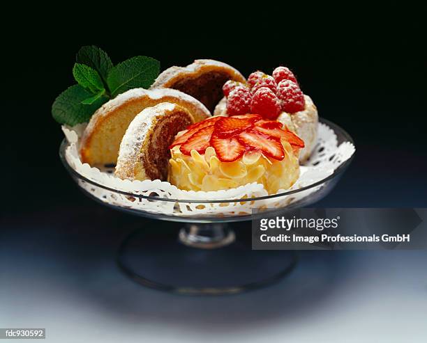 two small cakes with berries and a few pieces of marble cake - marble - fotografias e filmes do acervo