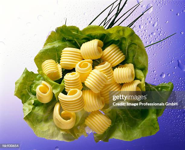 several butter curls arranged on a lettuce leaf - leaf lettuce stock-fotos und bilder