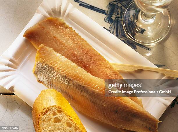 two matje herrings with bread in cardboard dish - kipper stock pictures, royalty-free photos & images