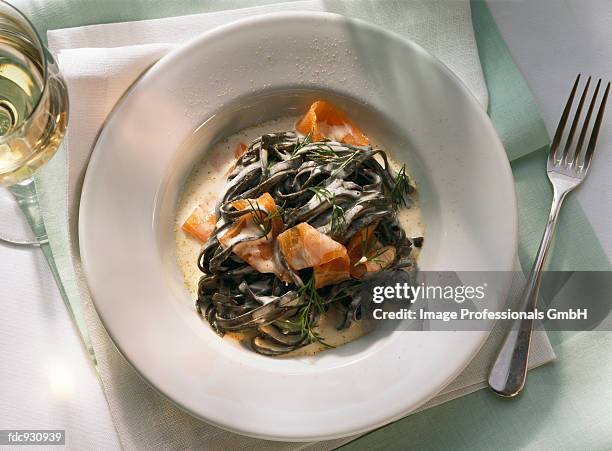black ribbon pasta with smoked salmon and cream sauce - savory sauce fotografías e imágenes de stock