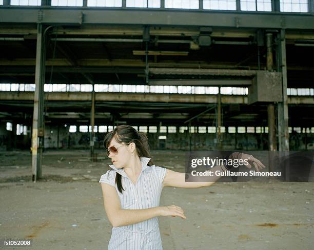 a woman dancing in front of an industrial construction site - simoneau stock-fotos und bilder