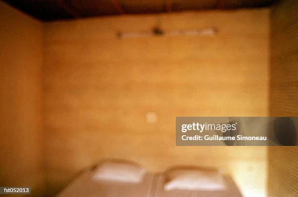 a bed in a wooden room - simoneau stock-fotos und bilder