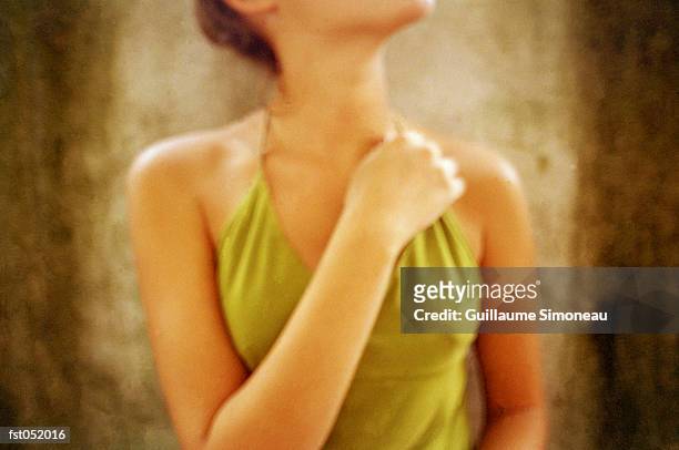 a young woman crossing an arm across her chest - simoneau stock-fotos und bilder