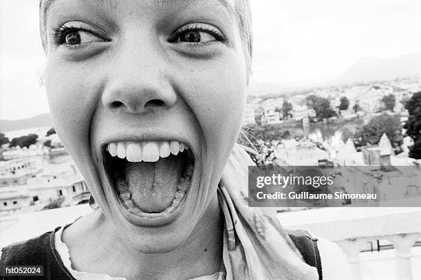 a woman smiling while looking to her right above a city - simoneau stock-fotos und bilder