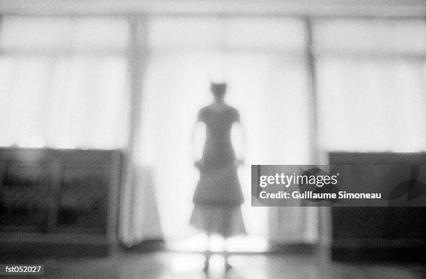 a woman standing in a bright doorway - simoneau stock-fotos und bilder