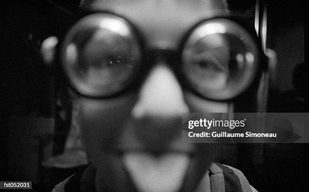 a teenager wearing funny glasses sticks his tongue out - simoneau stock-fotos und bilder