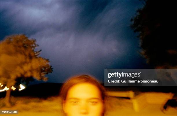 a young woman standing under storm clouds - simoneau stock-fotos und bilder