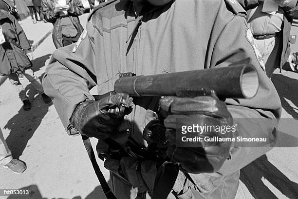 a riot policeman holding a tear gas launcher - simoneau stock-fotos und bilder
