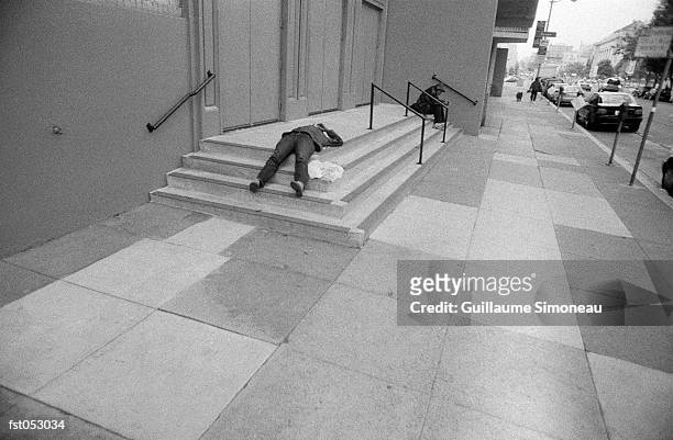 a man lying on concrete steps - simoneau stock-fotos und bilder