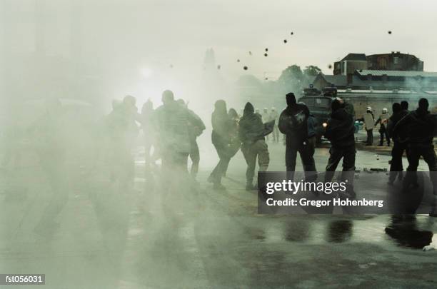 rioters throwing stones at police - riot stock-fotos und bilder