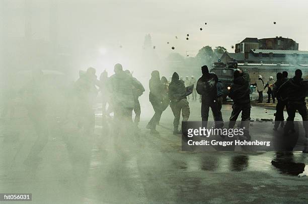 rioters throwing stones at police - riot stock pictures, royalty-free photos & images