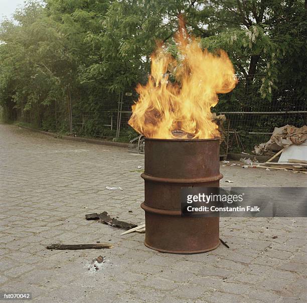 a fire burning in a barrel - ölfass stock-fotos und bilder