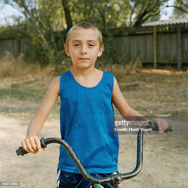 a boy sitting on a bicycle - vest stock pictures, royalty-free photos & images