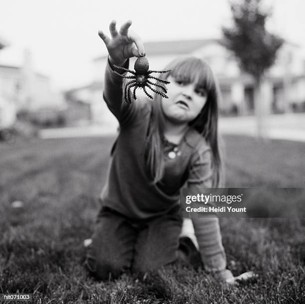 a girl holding a fake spider - heidi stock-fotos und bilder