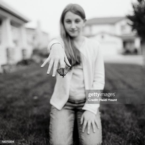 a girl holding a butterfly - heidi stock pictures, royalty-free photos & images