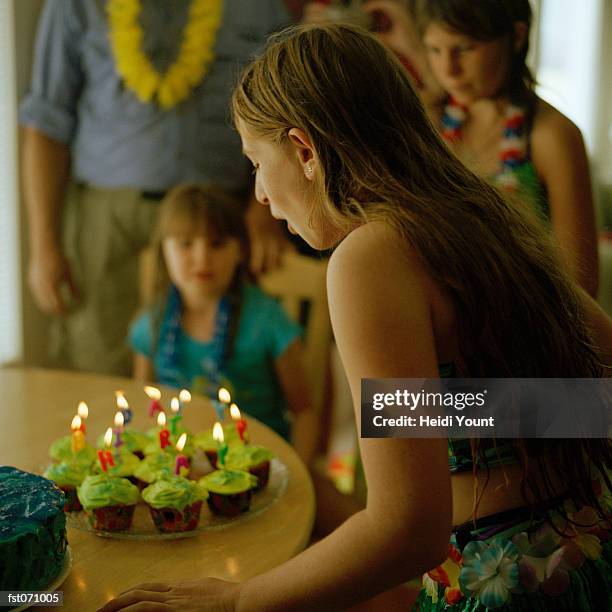 a girl blowing out the candles at a birthday party - heidi stock pictures, royalty-free photos & images