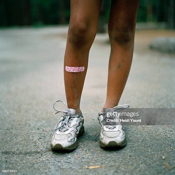 an adhesive bandage on a child's leg - heidi stock-fotos und bilder