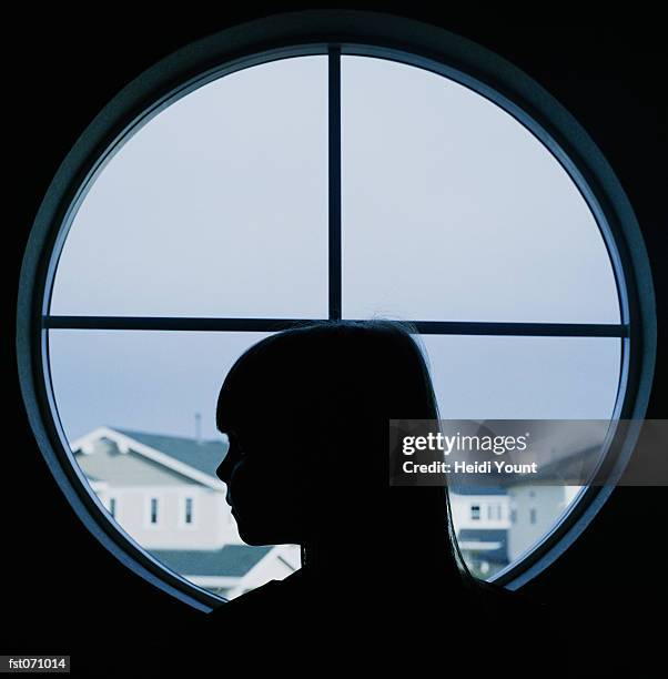 a child in profile in a round window - heidi stock pictures, royalty-free photos & images