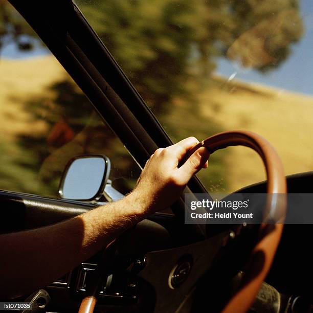 a person's hand on a steering wheel - heidi stock-fotos und bilder