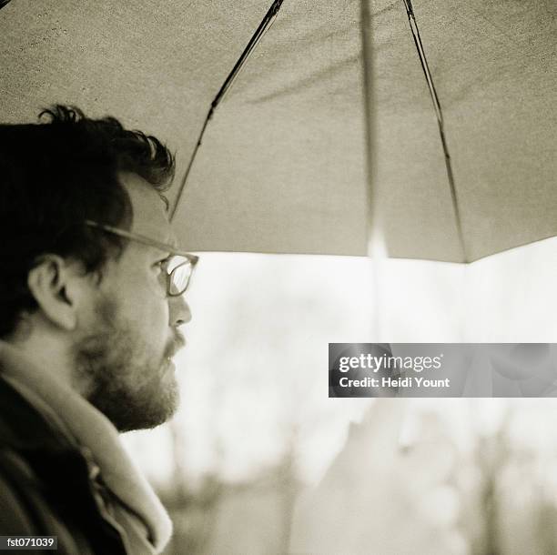 a man holding an umbrella - heidi stock-fotos und bilder