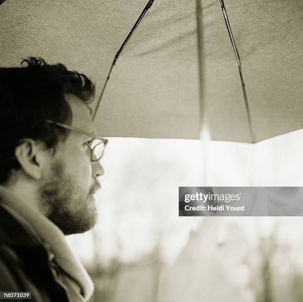 a man holding an umbrella - heidi stock pictures, royalty-free photos & images