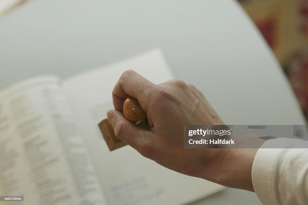 A hand holding a stamp