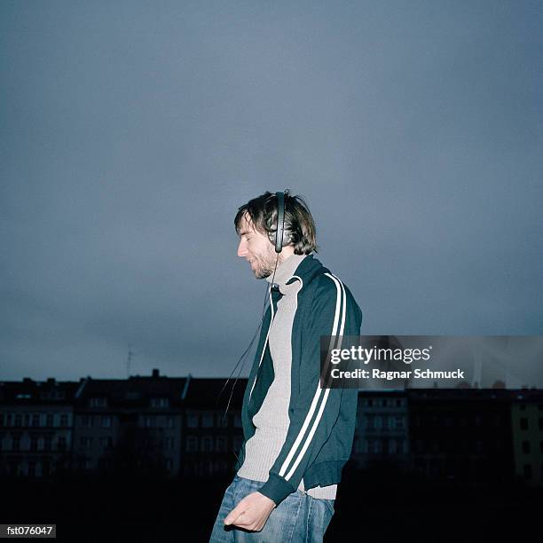 a young man listening to music on headphones - schmuck - fotografias e filmes do acervo