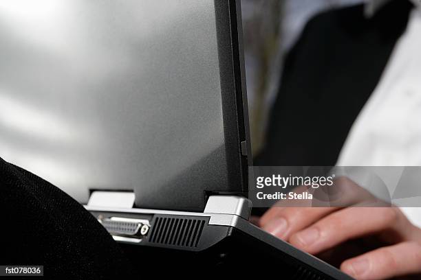 a businessman typing on a laptop computer - datorport bildbanksfoton och bilder