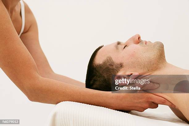 a massage therapist massaging a man?s neck - stella stock pictures, royalty-free photos & images