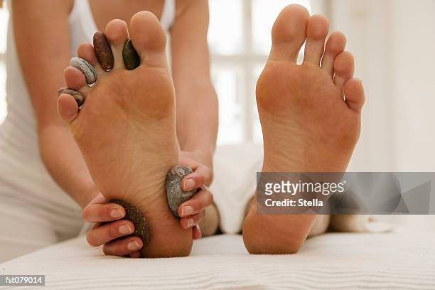 a massage therapist massaging a man?s feet - stella stock pictures, royalty-free photos & images
