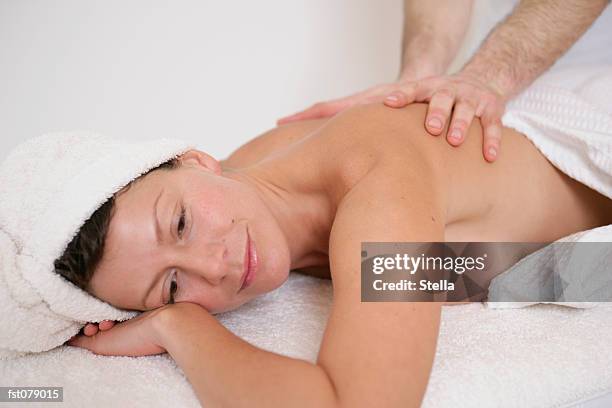 a massage therapist massaging a woman?s back - stella stock-fotos und bilder