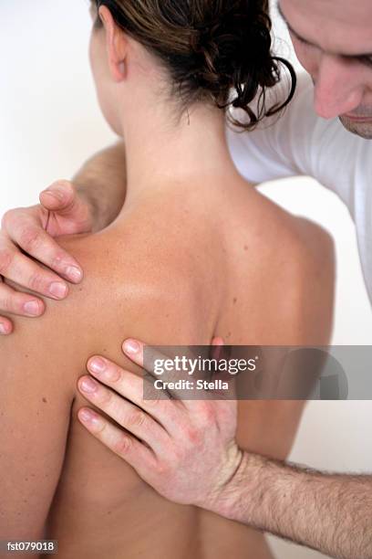 a massage therapist massaging a woman?s back - stella stockfoto's en -beelden