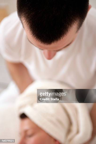a massage therapist massaging a woman?s neck - stella stock-fotos und bilder