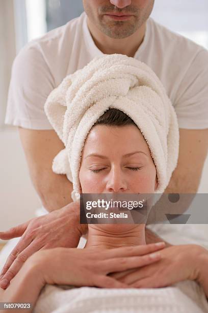 a massage therapist massaging a woman?s shoulders - stella stock pictures, royalty-free photos & images