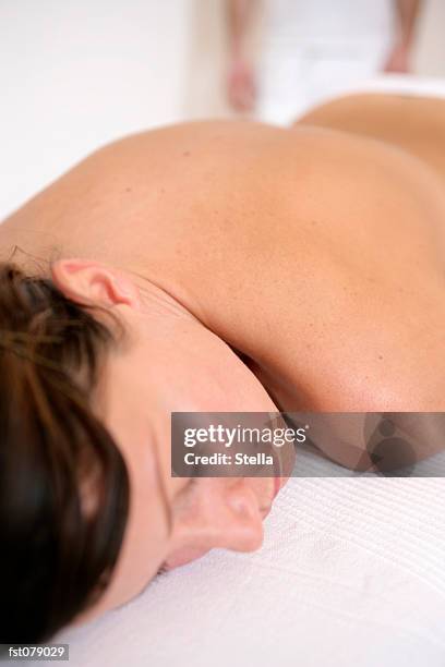 a woman lying on a massage table - stella stockfoto's en -beelden