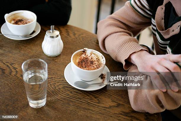 close-up of two people sitting in a cafe - sugar shaker stock pictures, royalty-free photos & images