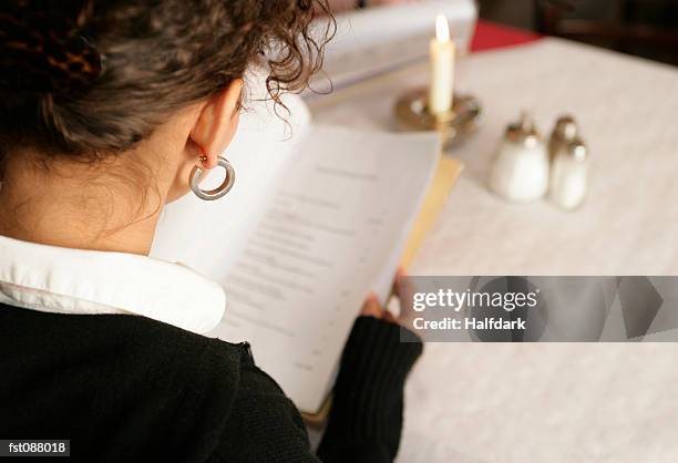 a woman reading a menu in a cafe - sugar shaker stock pictures, royalty-free photos & images