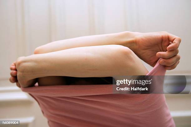 woman taking off sweater - spogliarsi foto e immagini stock