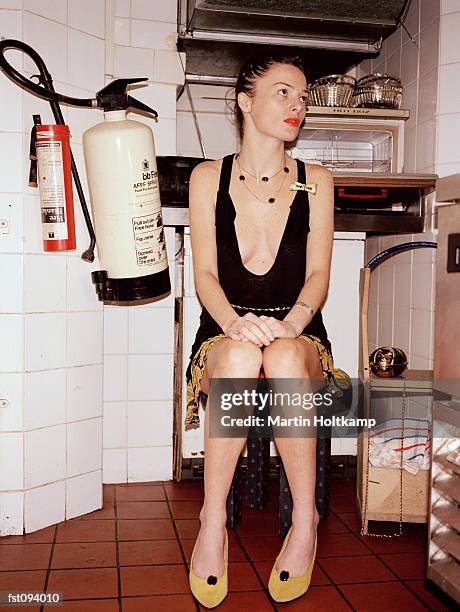 woman sitting on a stool - noodapparatuur stockfoto's en -beelden