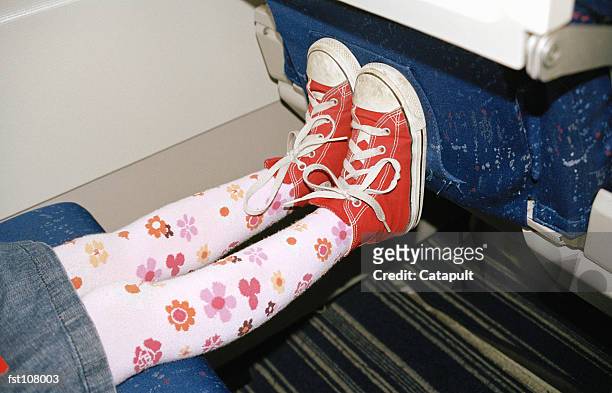 child?s feet against airplane seat - leg stretch girl stock pictures, royalty-free photos & images