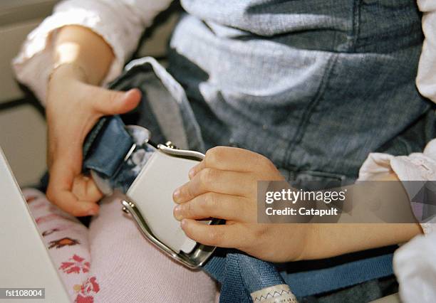 child fastening airplane seat belt - airplane-seat-belt stock pictures, royalty-free photos & images