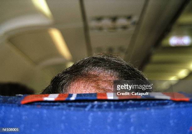 back of man?s head obscured by airplane seat - head rest stock pictures, royalty-free photos & images