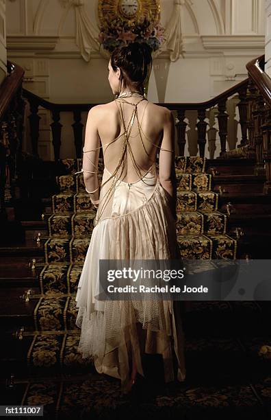 woman in evening gown walking up stairs - vestido-de-noche fotografías e imágenes de stock