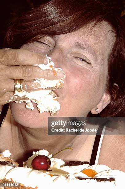 woman eating cake with hand - rache stock pictures, royalty-free photos & images